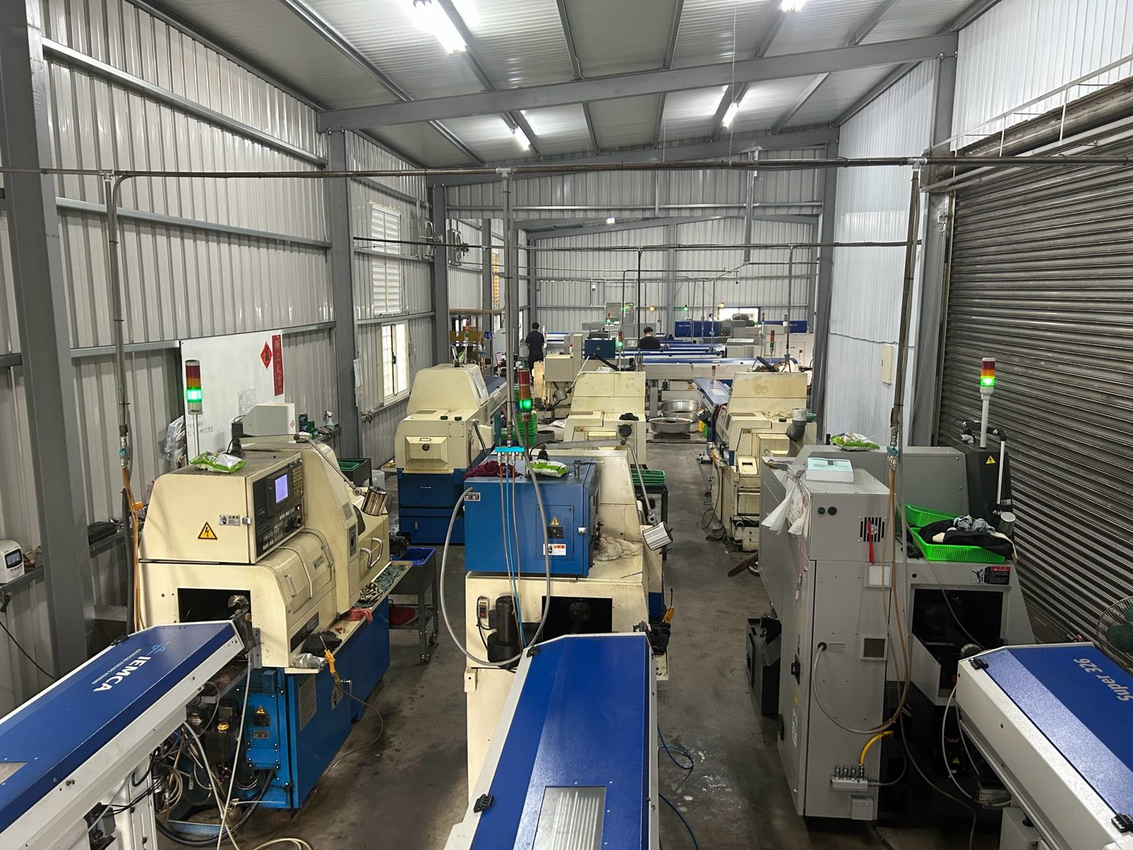 走心式 CNC 車床與送料機並列的廠內走道